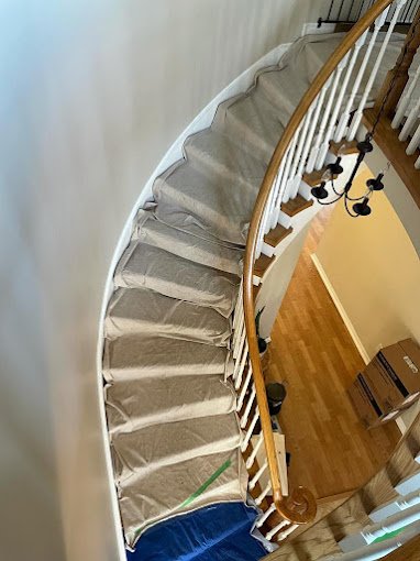 Crew lays drop cloths on every stair and the landing to protect the home during a bathroom renovation